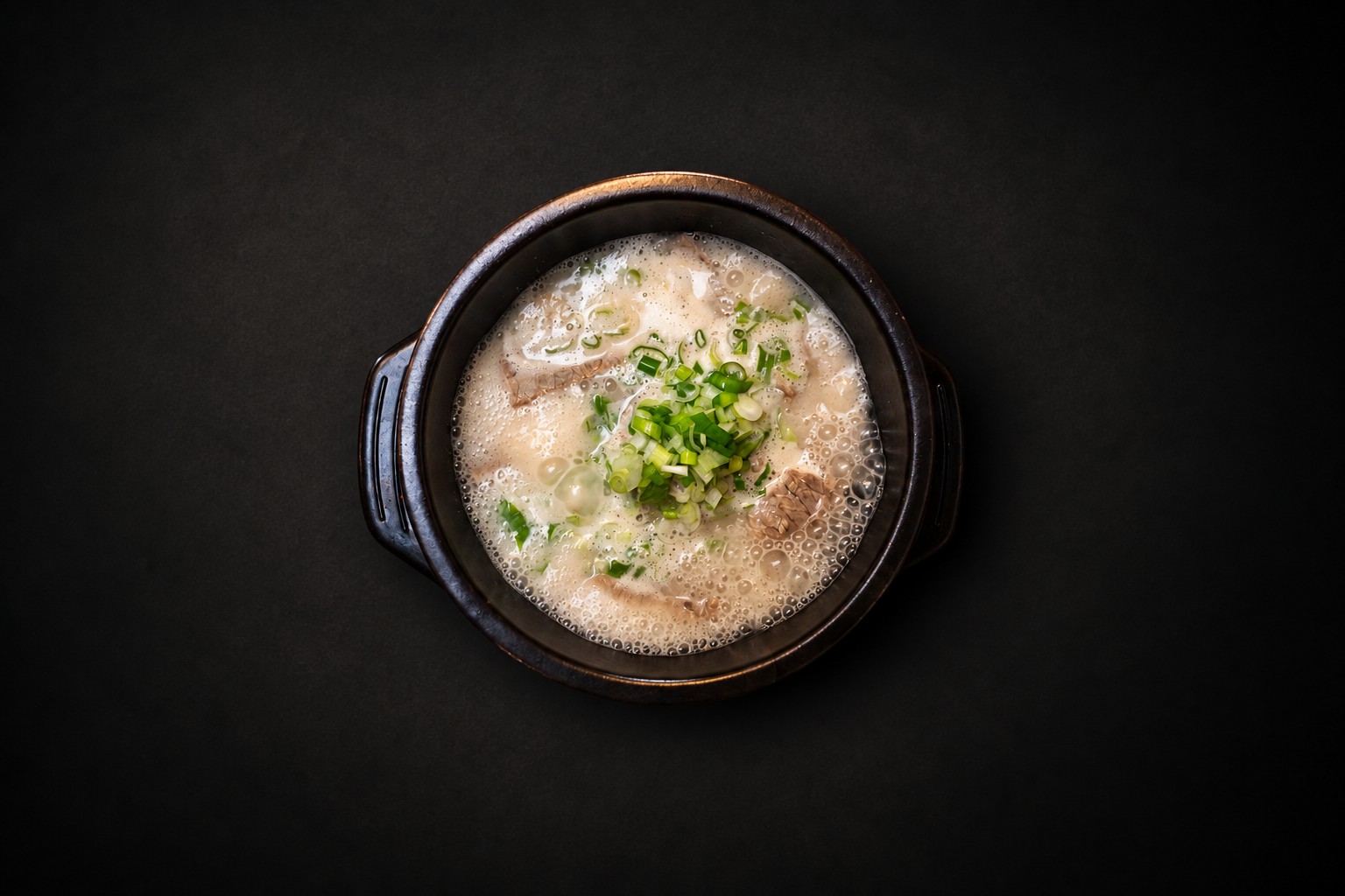 A pale broth topped with chopped green onions