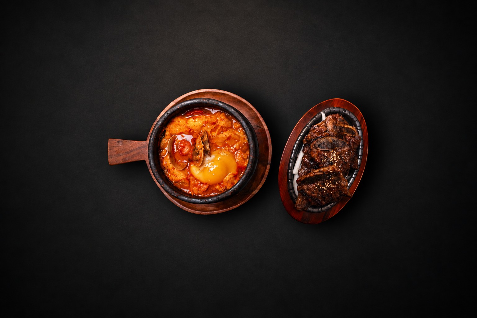 Red stew and grilled meat on wooden serving boards