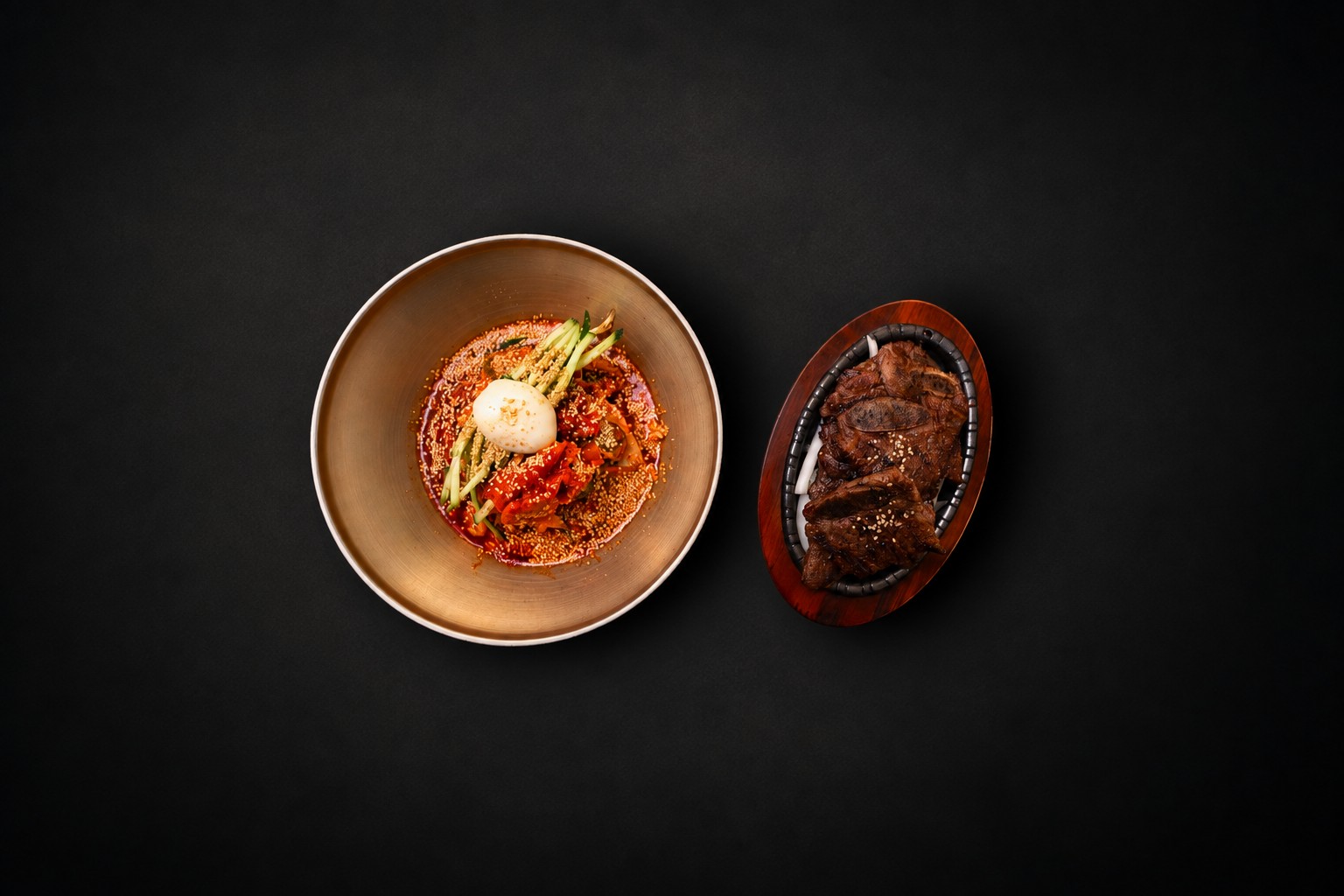 Red noodles with cucumber and egg beside grilled meat