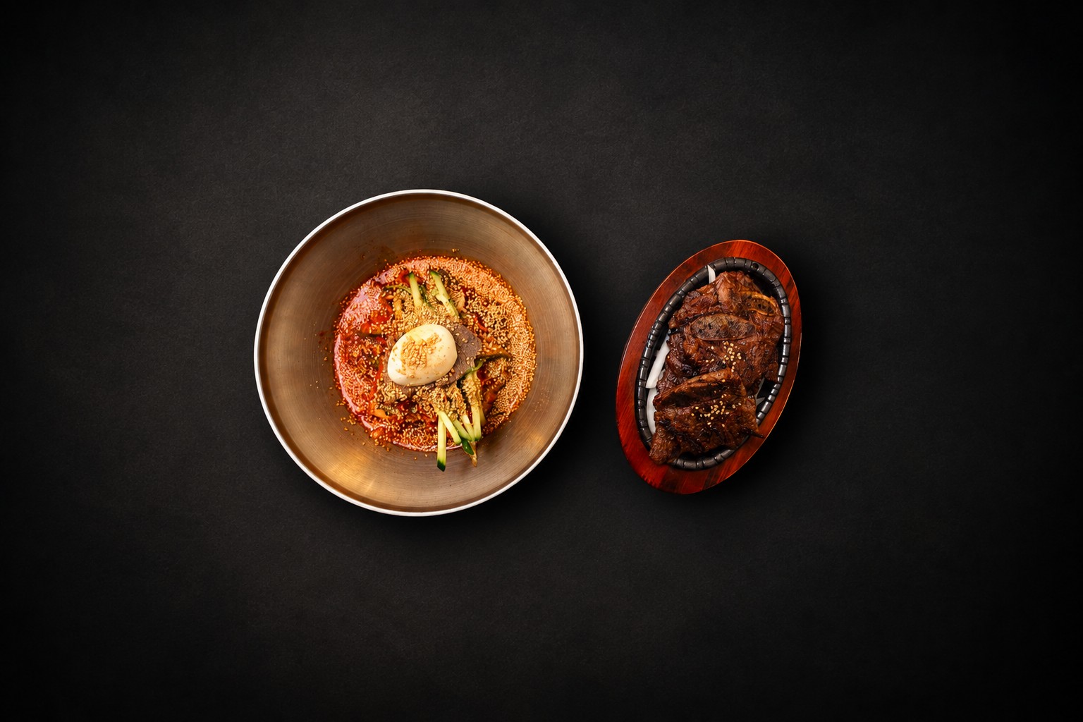 A golden noodle bowl paired with a sizzling meat platter